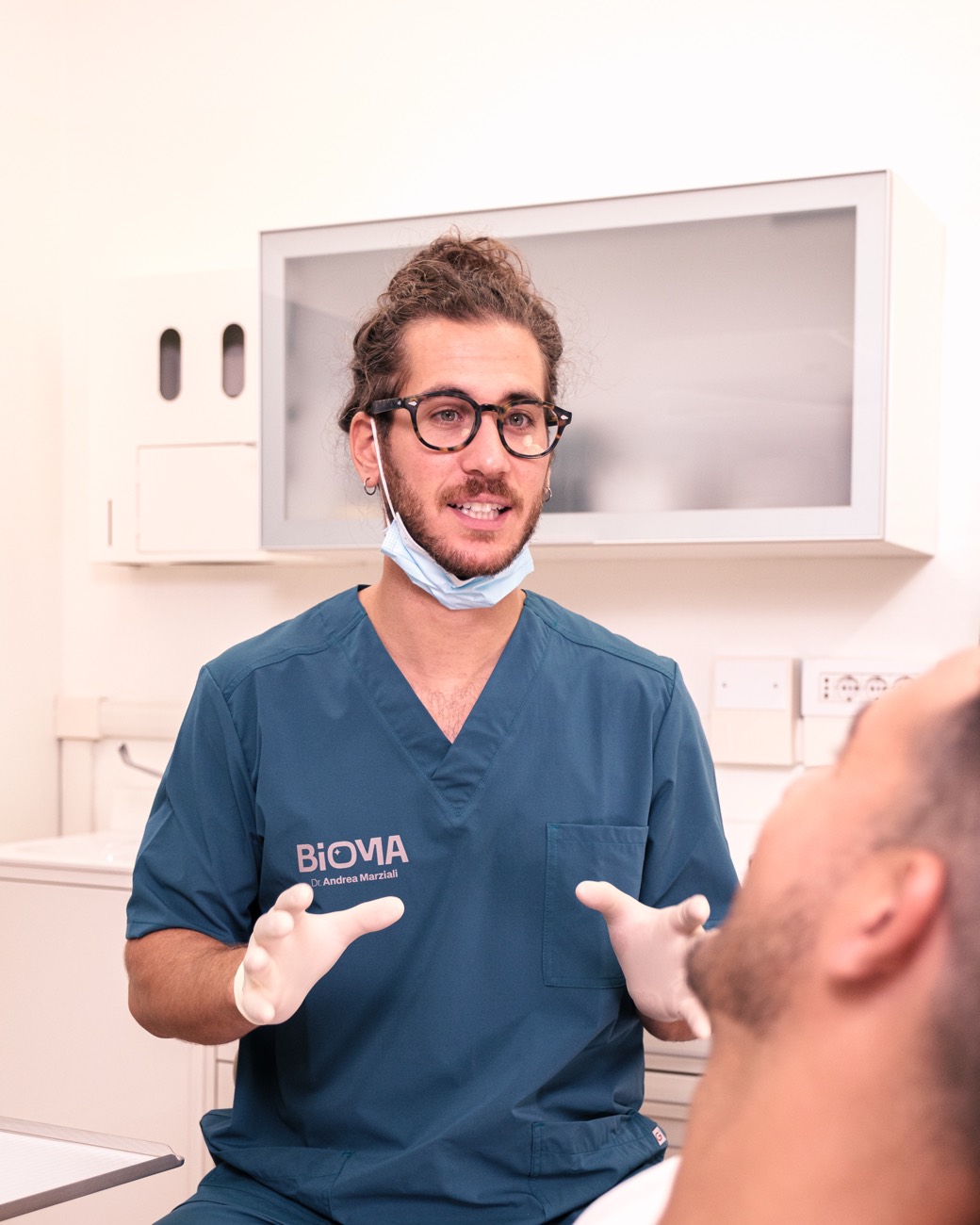 Il Dott. Marziali spiega con calma il trattamento a un paziente